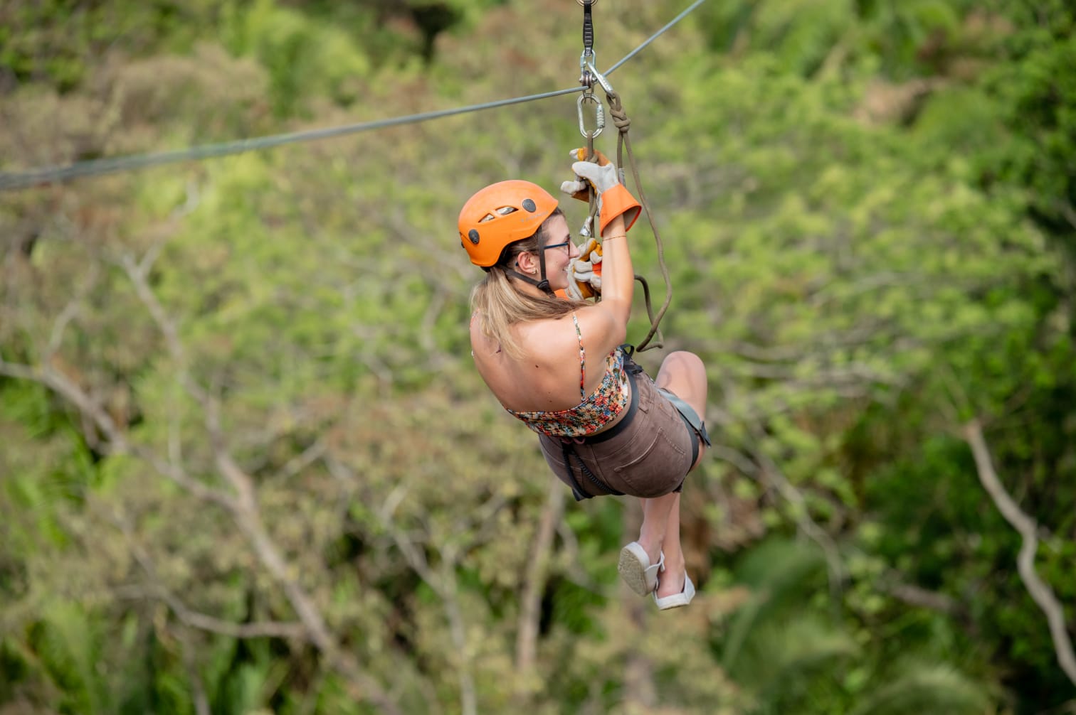 A visitor riding a zipline at Coco Jungle park in Roatán